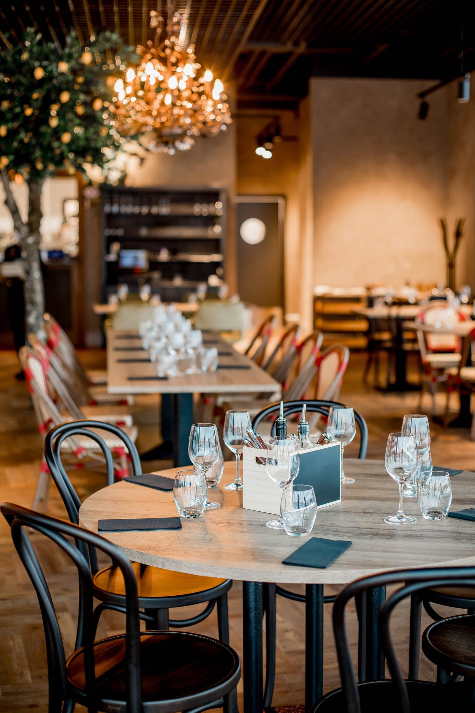 Sală de restaurant cu mese așezate și pahare de cristal
